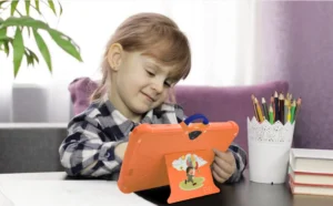 A child is using tablet for study and use laptop stand for proper using.